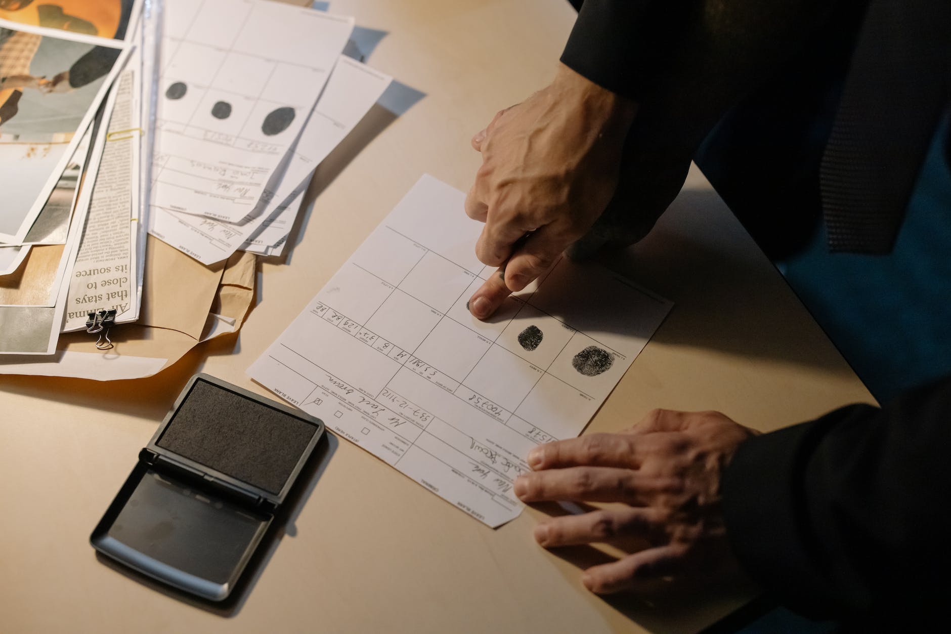person in black long sleeve putting fingerprint on paper